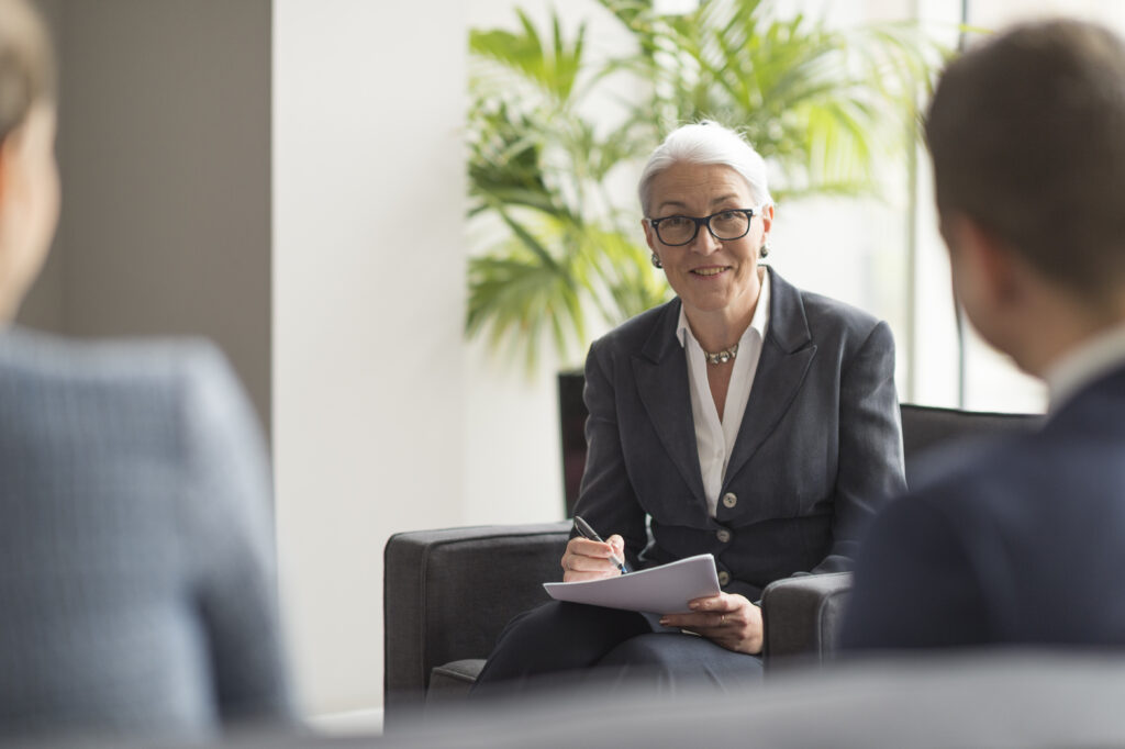Over shoulder view of businesswoman making notes in office meeting