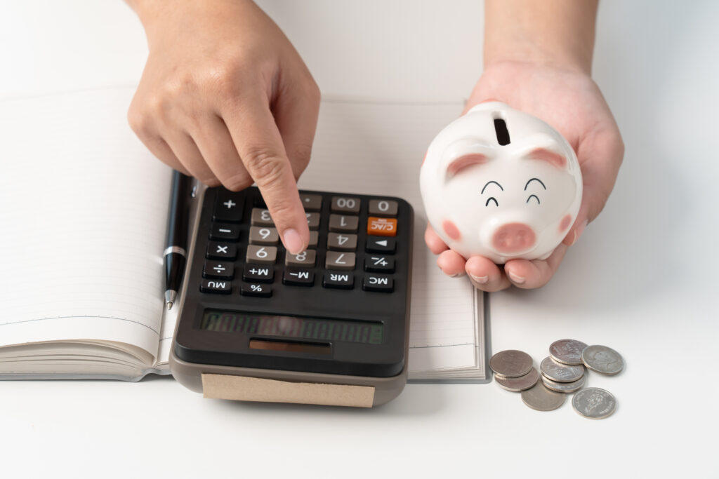 Woman save money in piggy bank and calculating for household expense